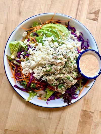 Southwest Salad with House Mixed Greens, Herb Pulled Chicken, Shredded Cabbage and Carrots, Roasted Corn, Sliced Avocado, Chipotle Buttermilk Dressing, Fried Tortilla Strips.